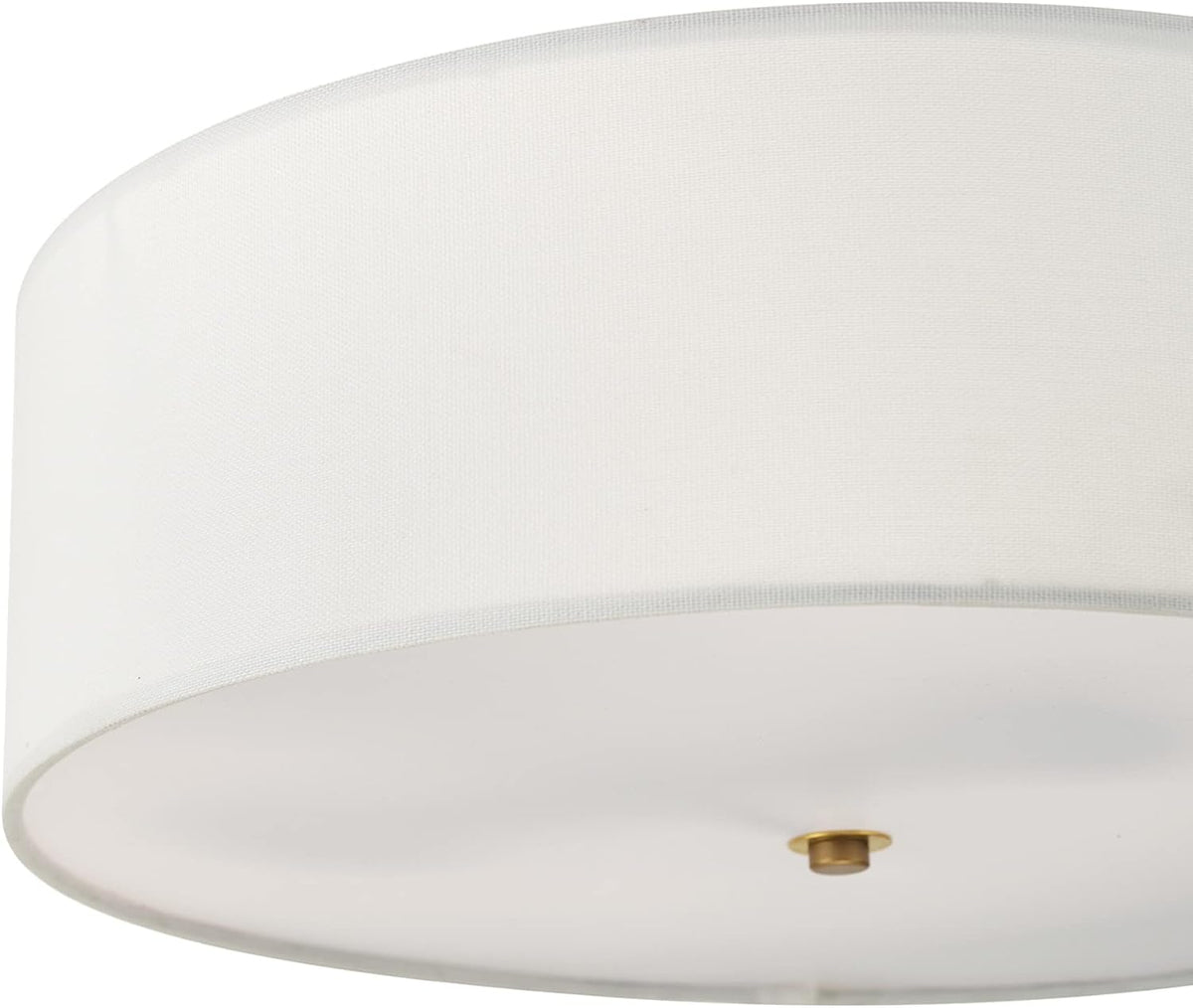 Low-angle close-up of the white linen drum shade and matte brass finial on the diffuser