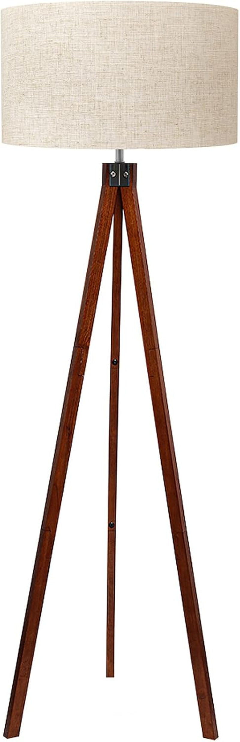 Brown rubberwood tripod floor lamp with beige linen drum shade, front view on white background