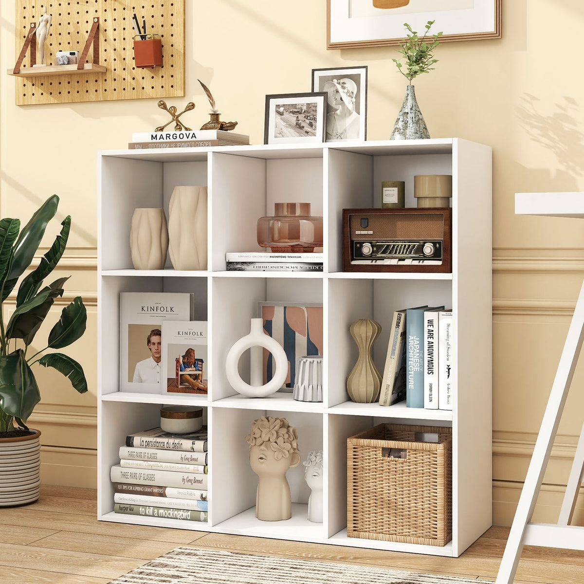 White cube bookcase filled with decor and storage baskets, shown against a warm yellow wall.