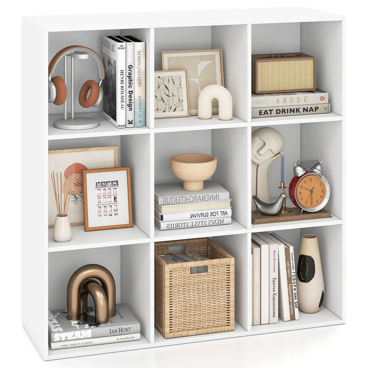 Front view of the white nine-cube bookcase, with books, baskets and decorative objects in its compartments.