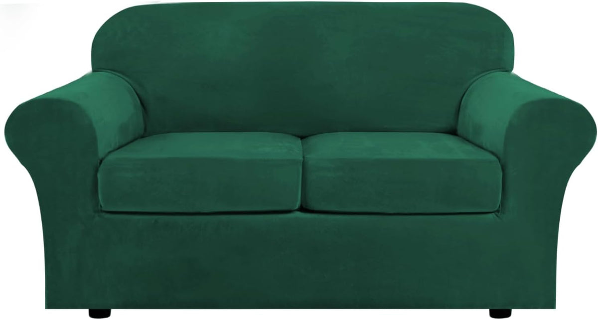 Front-facing two-seat loveseat covered in emerald green stretch velvet slipcover on white background