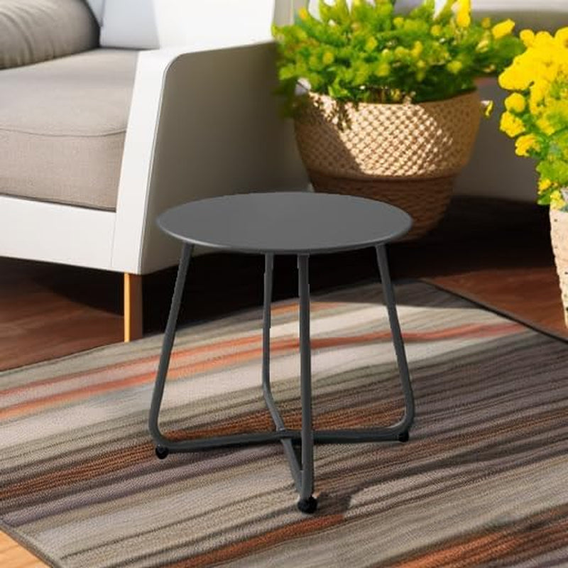 Black metal side table styled indoors on a rug next to a sofa and plant
