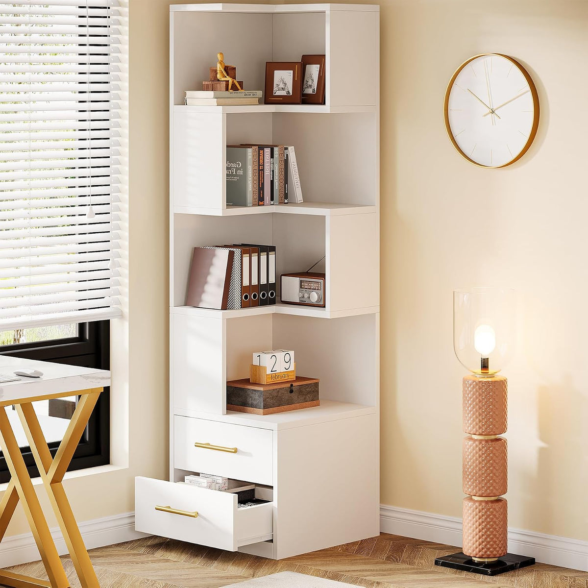 White corner bookcase displaying books and décor with drawers open