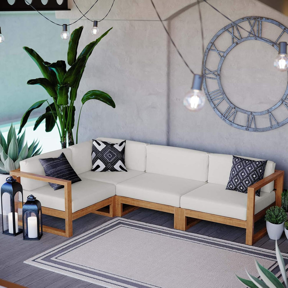 Natural teak 4-piece L-shaped outdoor sectional with white cushions, angled front view in a patio setting