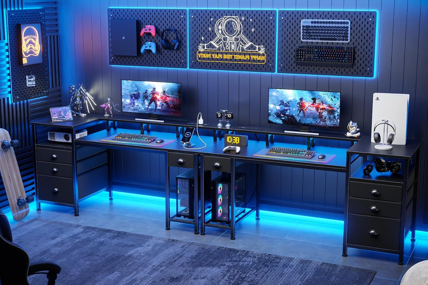 Wide gaming room view showing three joined desks, two PC towers under the center desk and illuminated wall panels