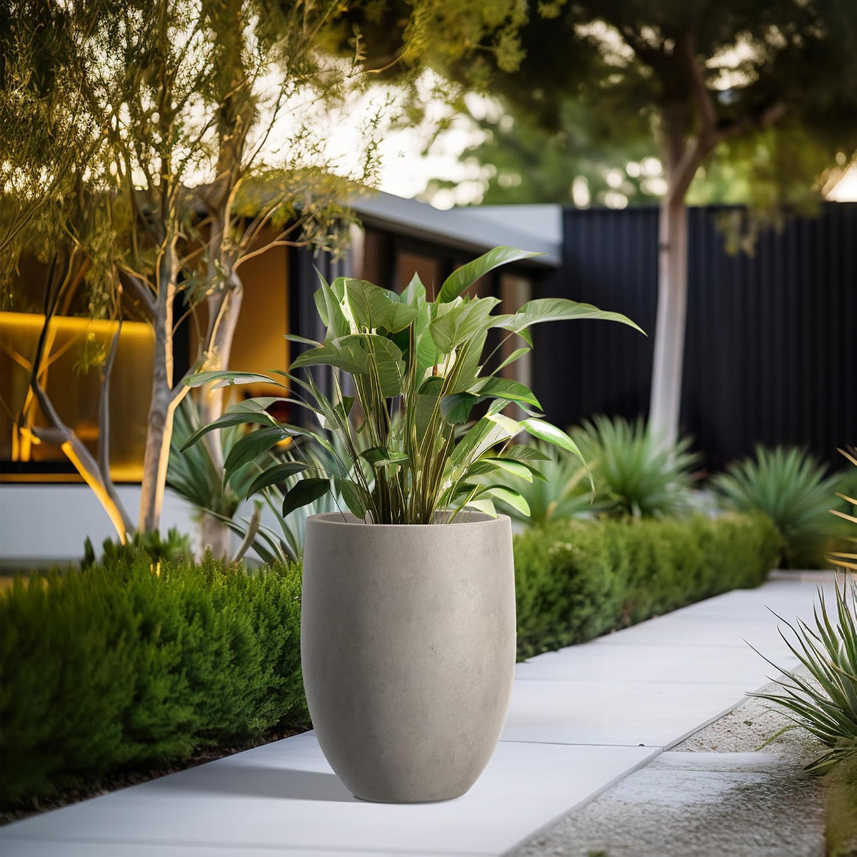 Pathway scene with tall concrete planters in a row on an outdoor walkway at dusk