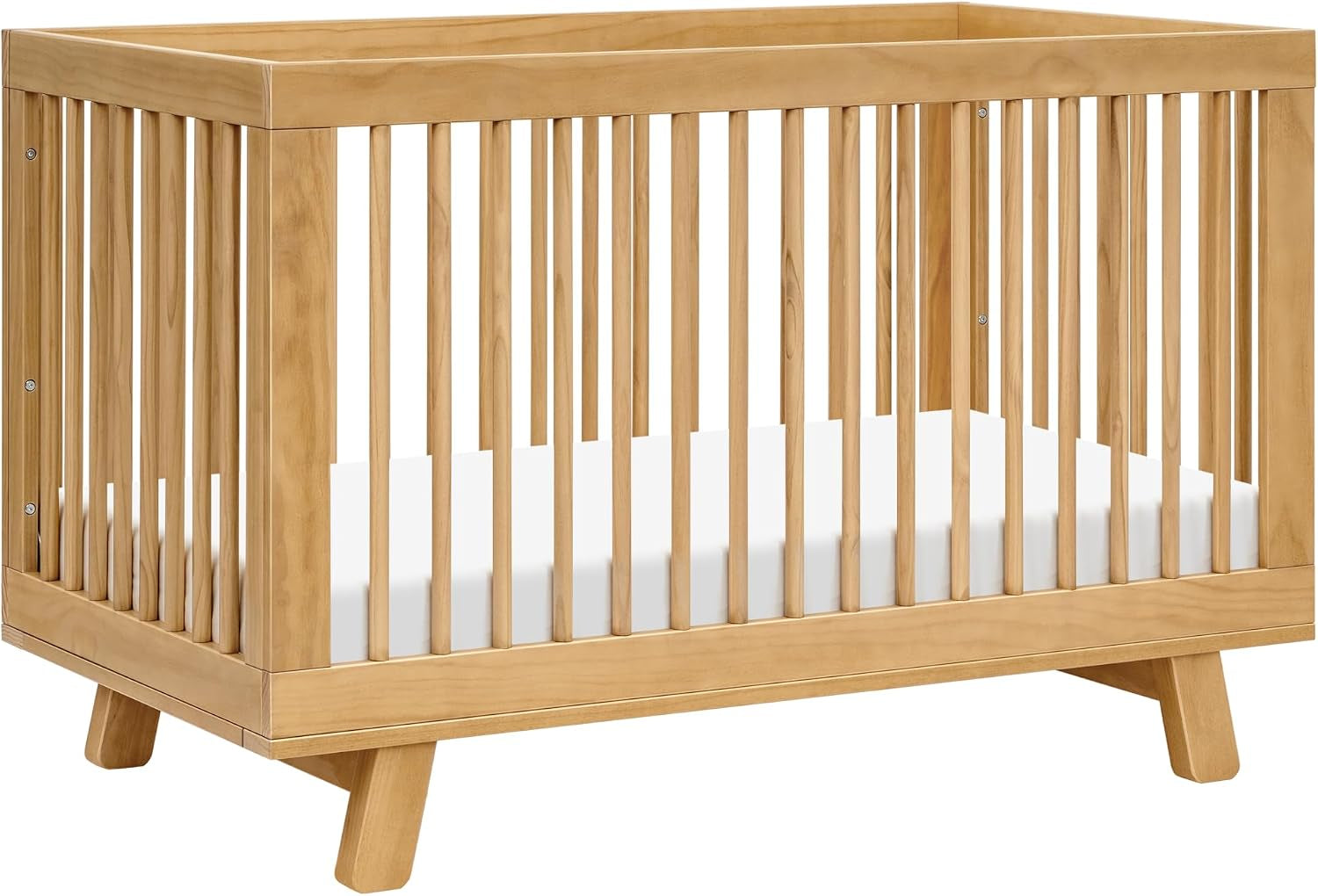 Angled view of a warm natural wood crib showing vertical slats and tapered legs.
