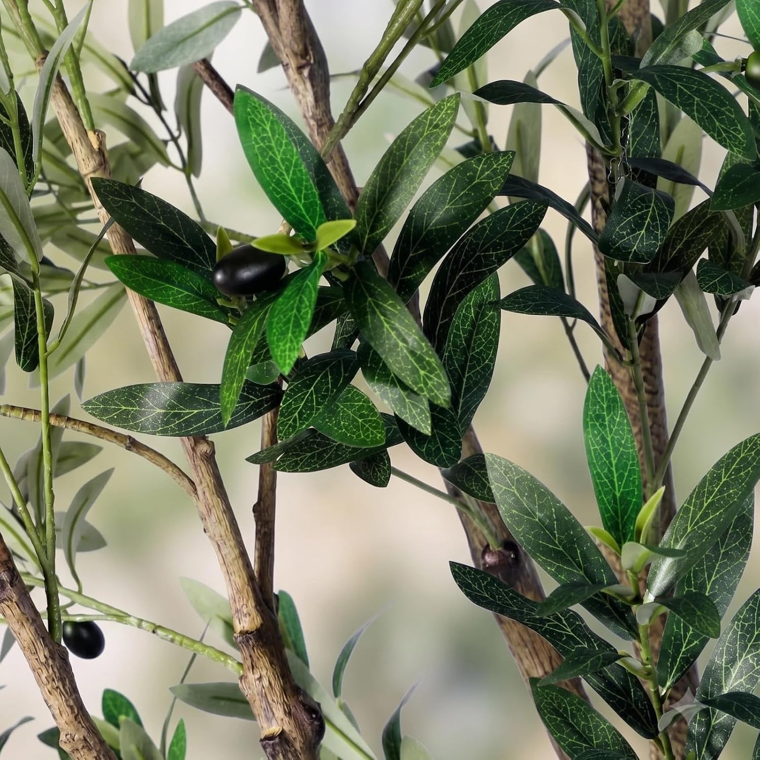 Close-up of silk olive leaves, plastic stems and small faux black olives on branches