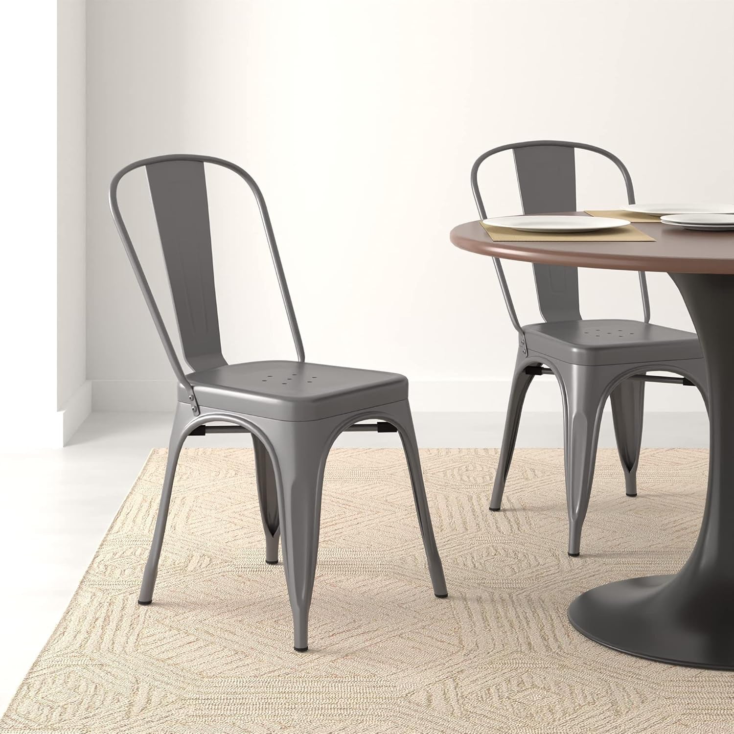 Single metal dining chair in a light dining room next to a round table on a textured rug