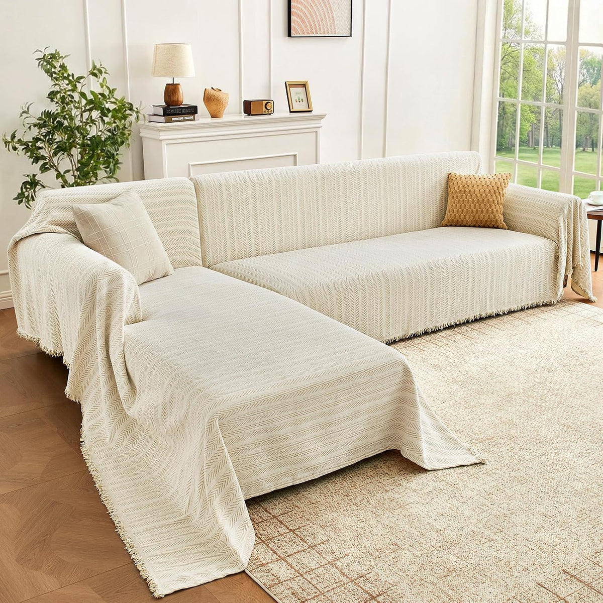 Front-right view of a cream herringbone cover on an L-shaped sectional in a sunlit living room with decorative pillows