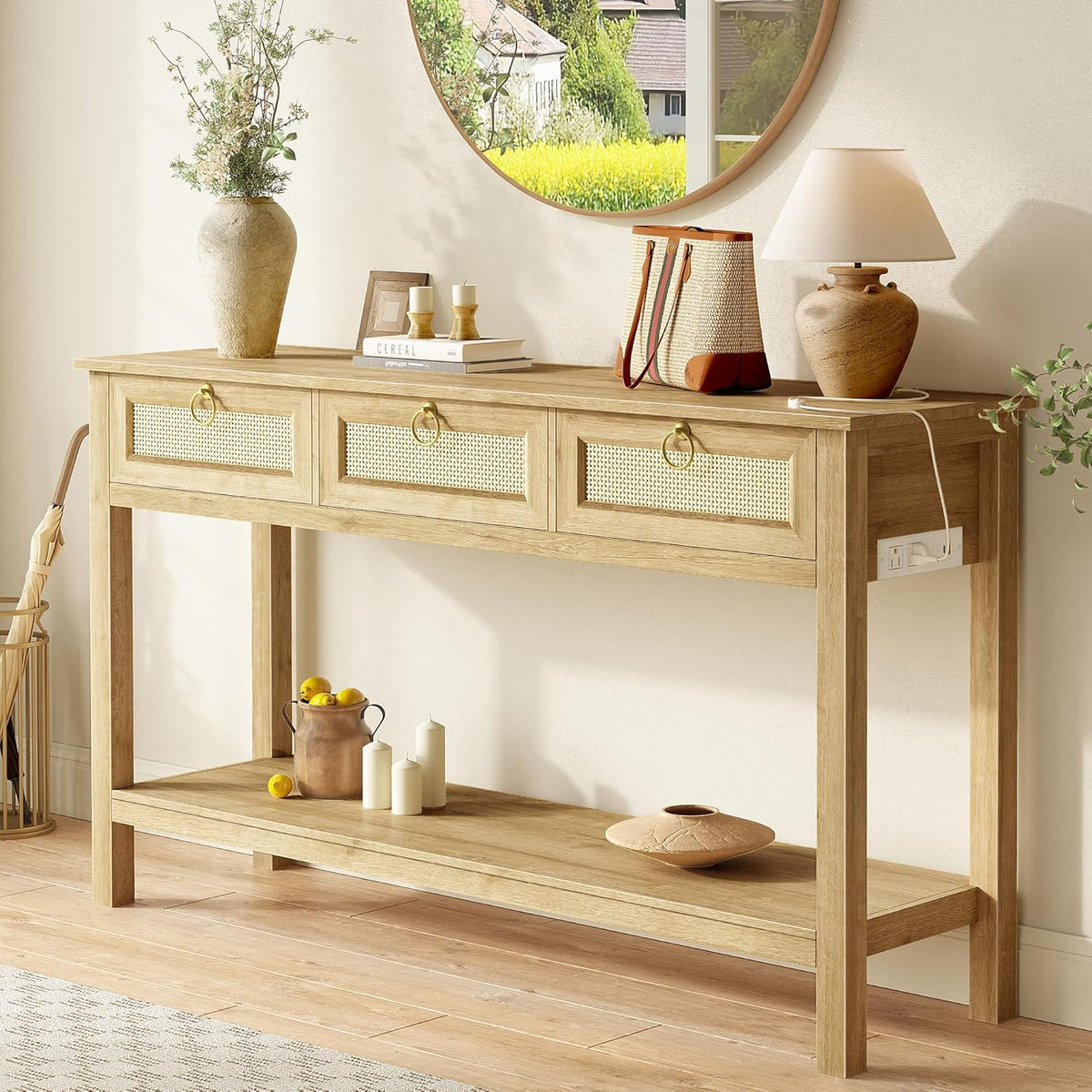 Light oak console table styled under a round mirror with lamp and decor, front view showing three cane-front drawers