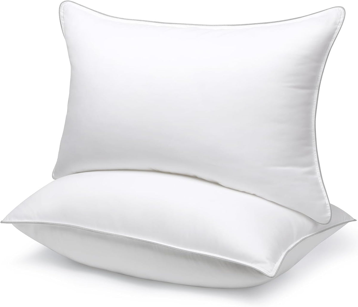Stacked white pillows with subtle gray piped edges shown against a white backdrop