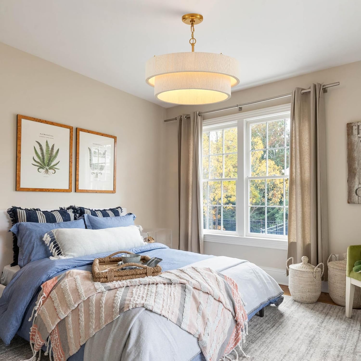Cream two-ring rattan chandelier centered in a bedroom with bed and window visible beneath