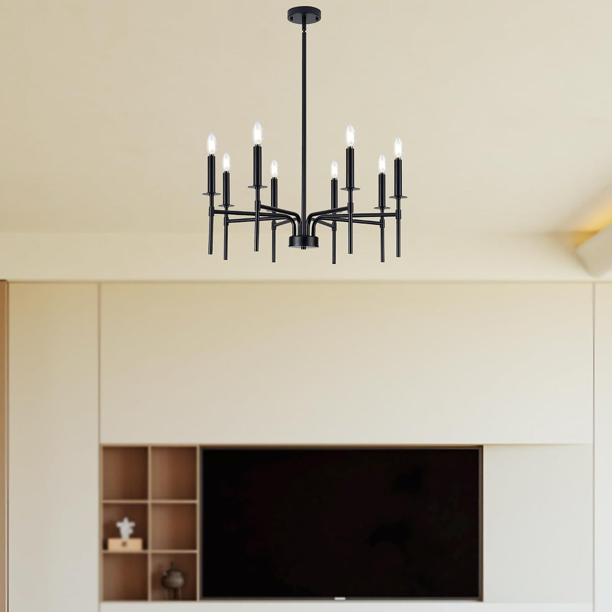 Black eight-light geometric chandelier hanging from the ceiling above a built-in media wall with TV and cubby shelves.