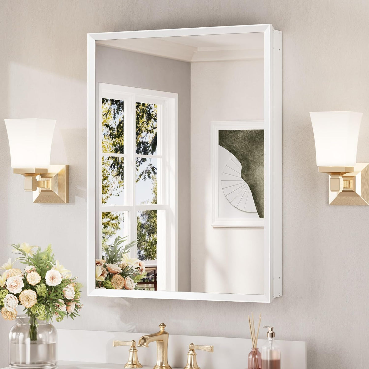 Wall-mounted white framed medicine cabinet with mirrored door above a sink, flanked by gold sconces.