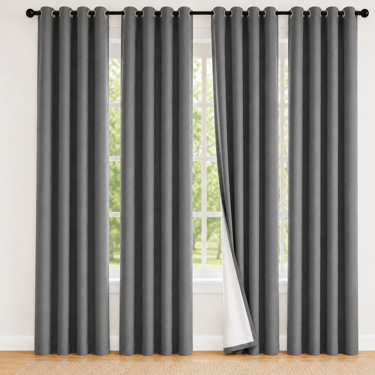 Full-height dark grey grommet curtains with one panel turned to reveal white backing