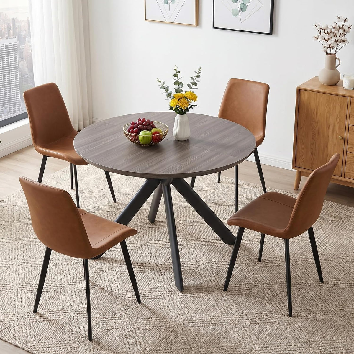 Dark gray round tabletop paired with four brown leather-look chairs on a patterned rug