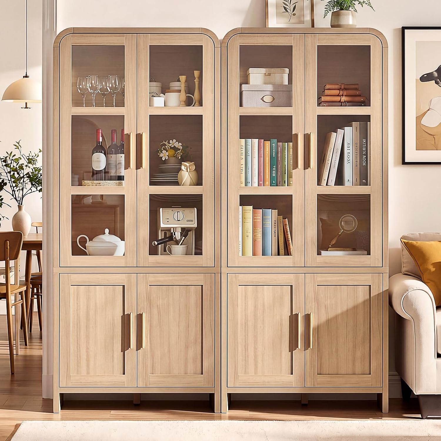 Two matching light-wood cabinets placed side by side holding glassware, books and decor