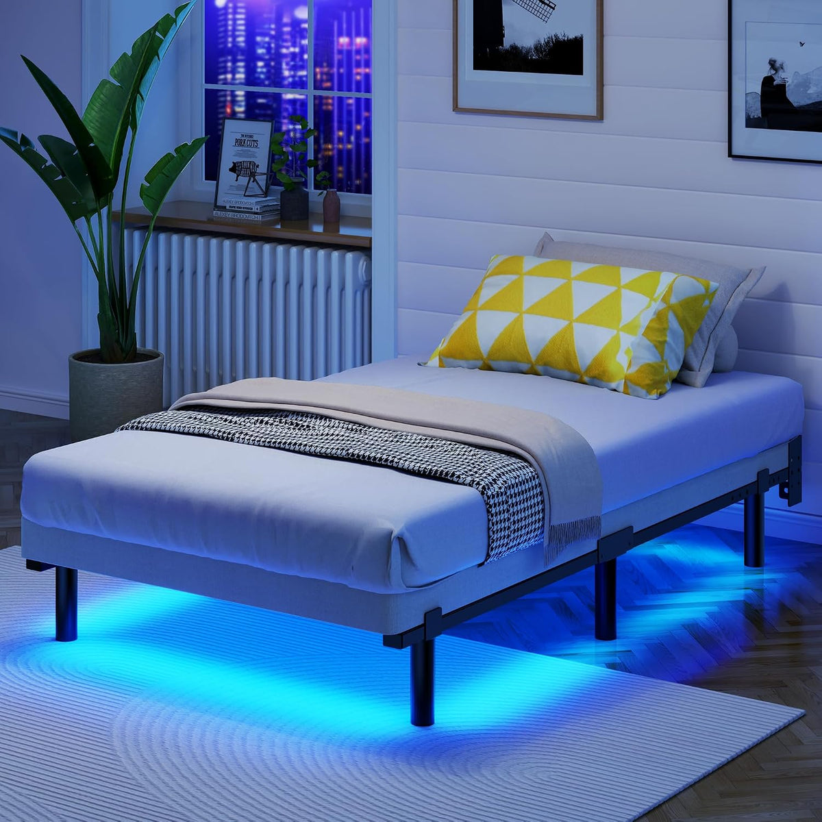 Nighttime bedroom with mattress on the black frame and blue LED underglow beneath the bed.