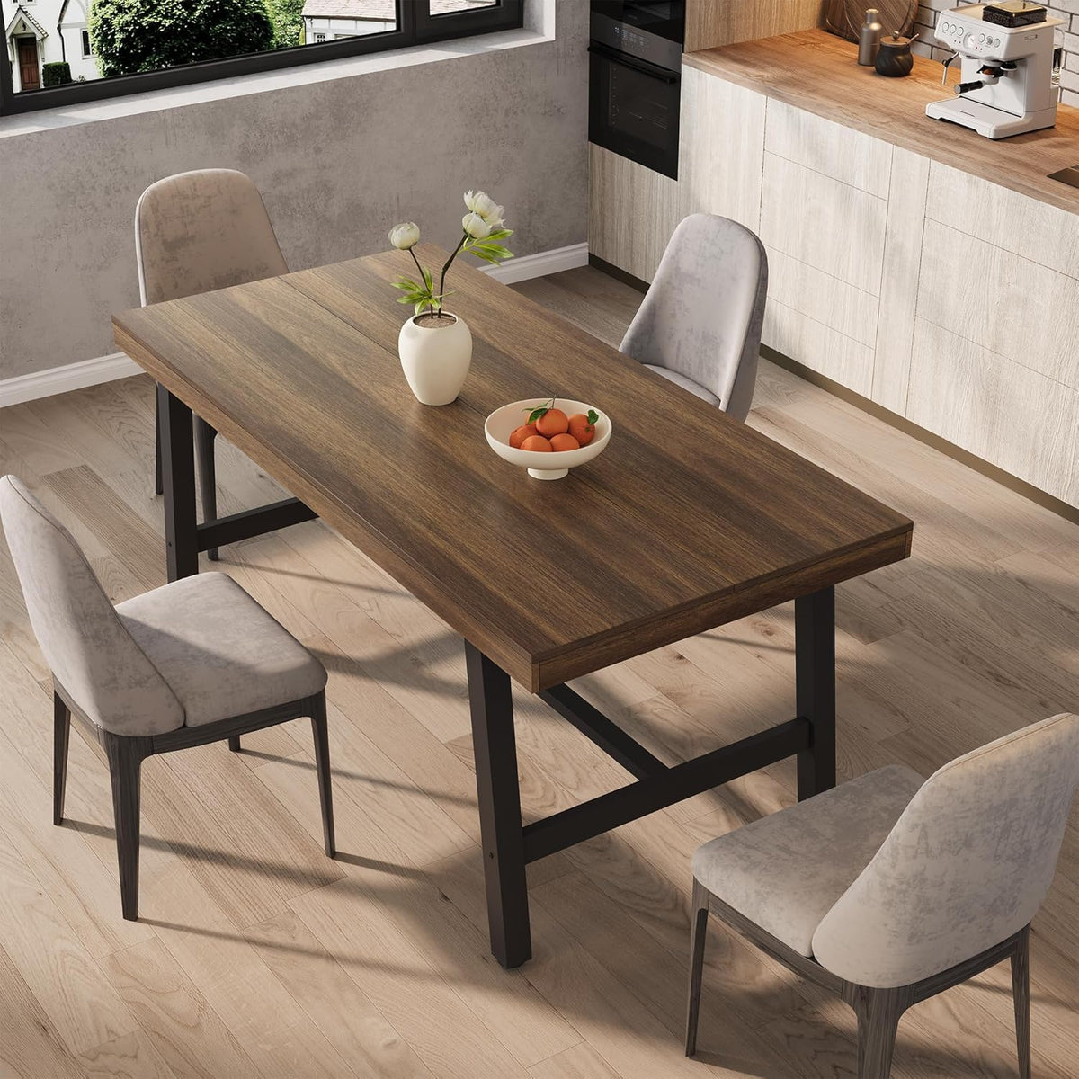 Angled top-side view highlighting the wood-grain tabletop with a bowl of oranges and light grey upholstered chairs.