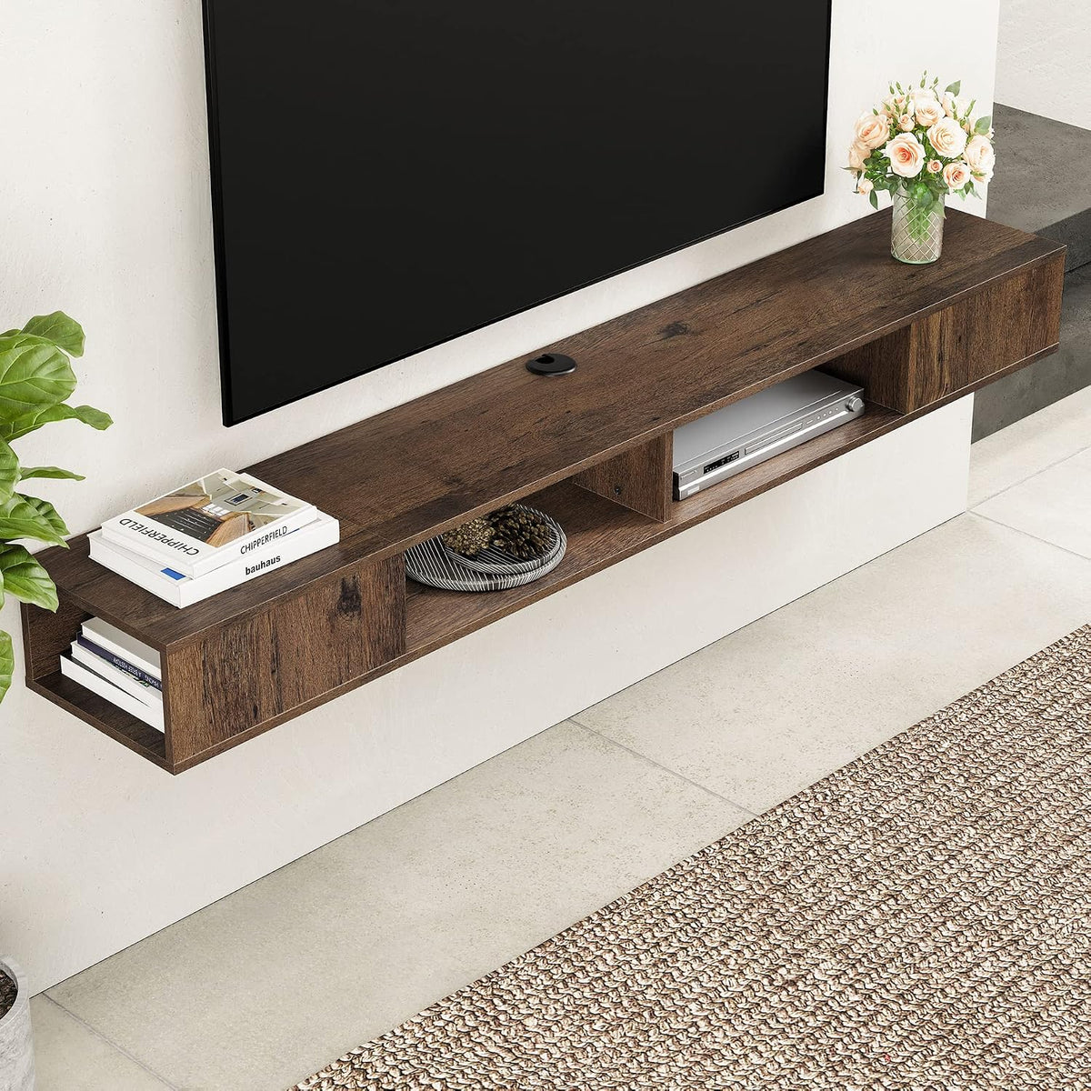 Angled close-up of the brown wall-mounted shelf showing its wood grain top, central cable grommet and open compartments with