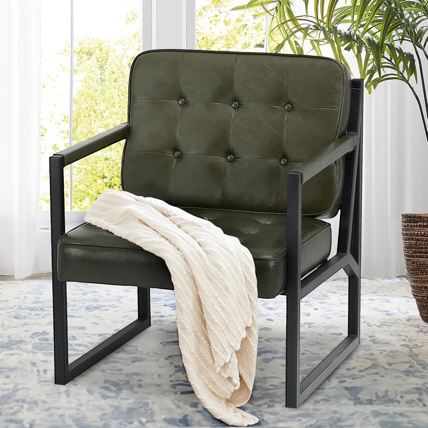 Close view of the same tufted faux-leather chair in an olive-green shade with a draped cream throw.