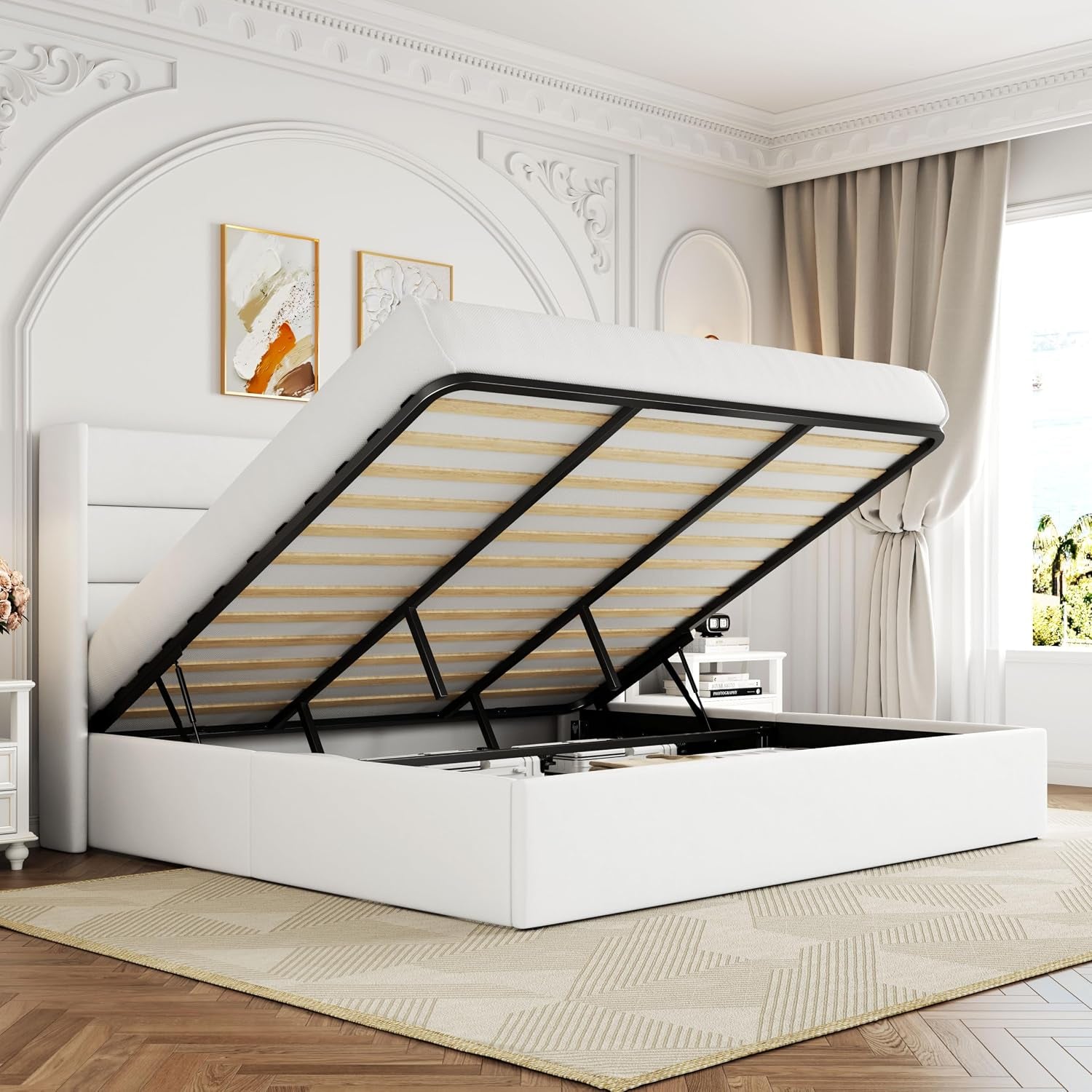 White upholstered bed seen from the side with slatted frame raised and empty storage compartment beneath