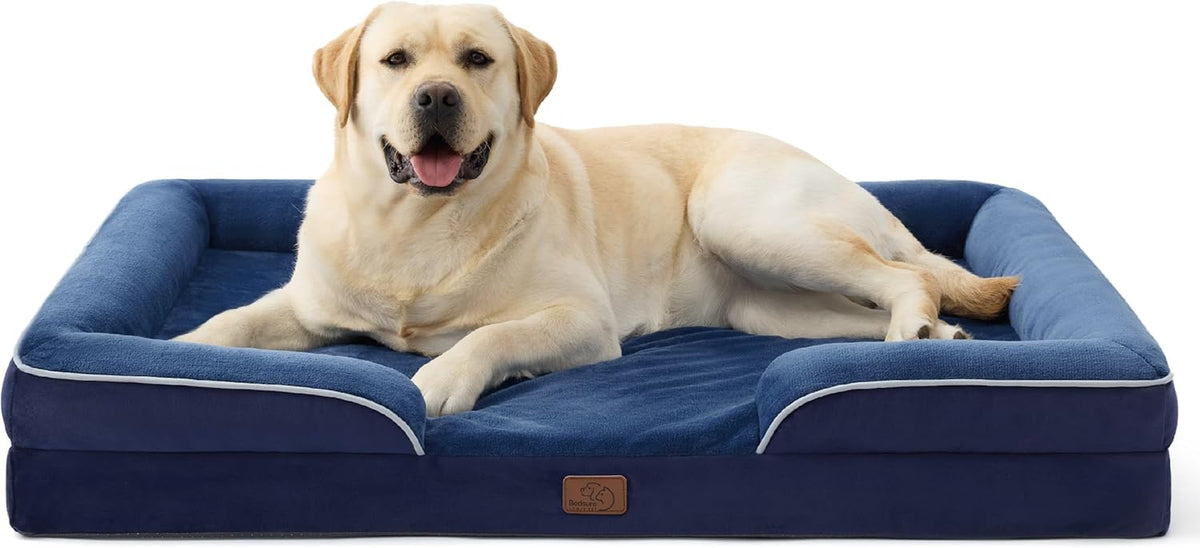 Navy blue bolstered rectangular dog bed with a yellow Labrador sprawled across the sleeping surface, front-facing