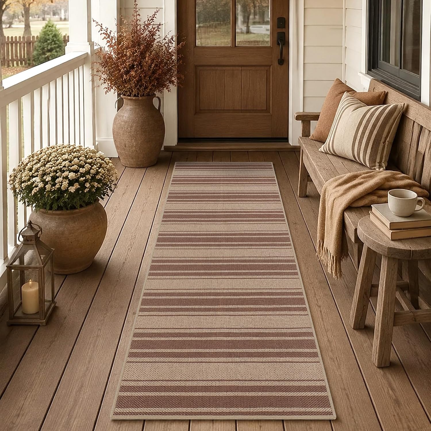Striped narrow runner laid on a porch floor with a wooden bench, pillows and ceramic pot.