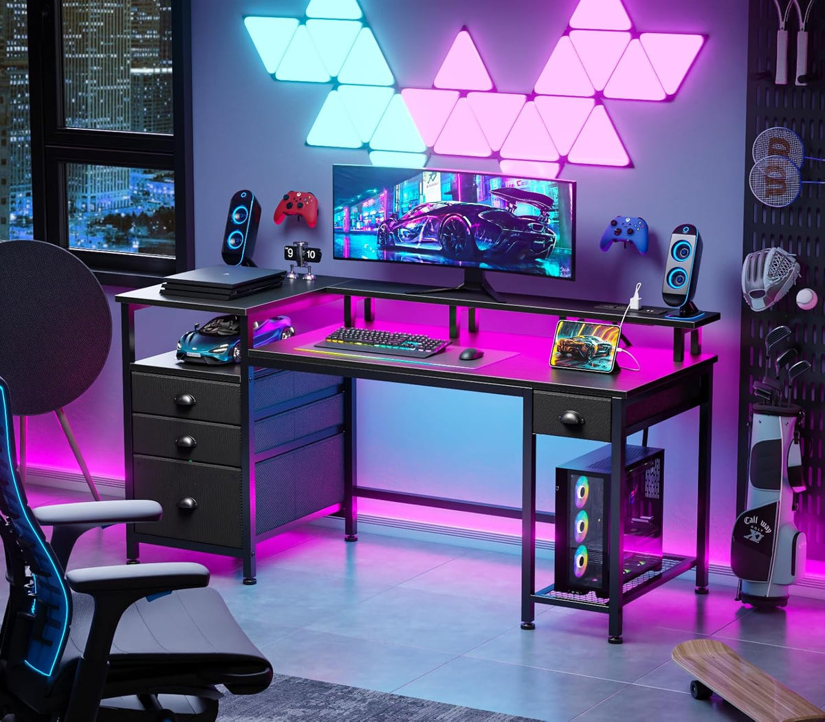 Styled gaming room scene showing the desk with bright magenta RGB lighting, monitor and fabric drawer unit