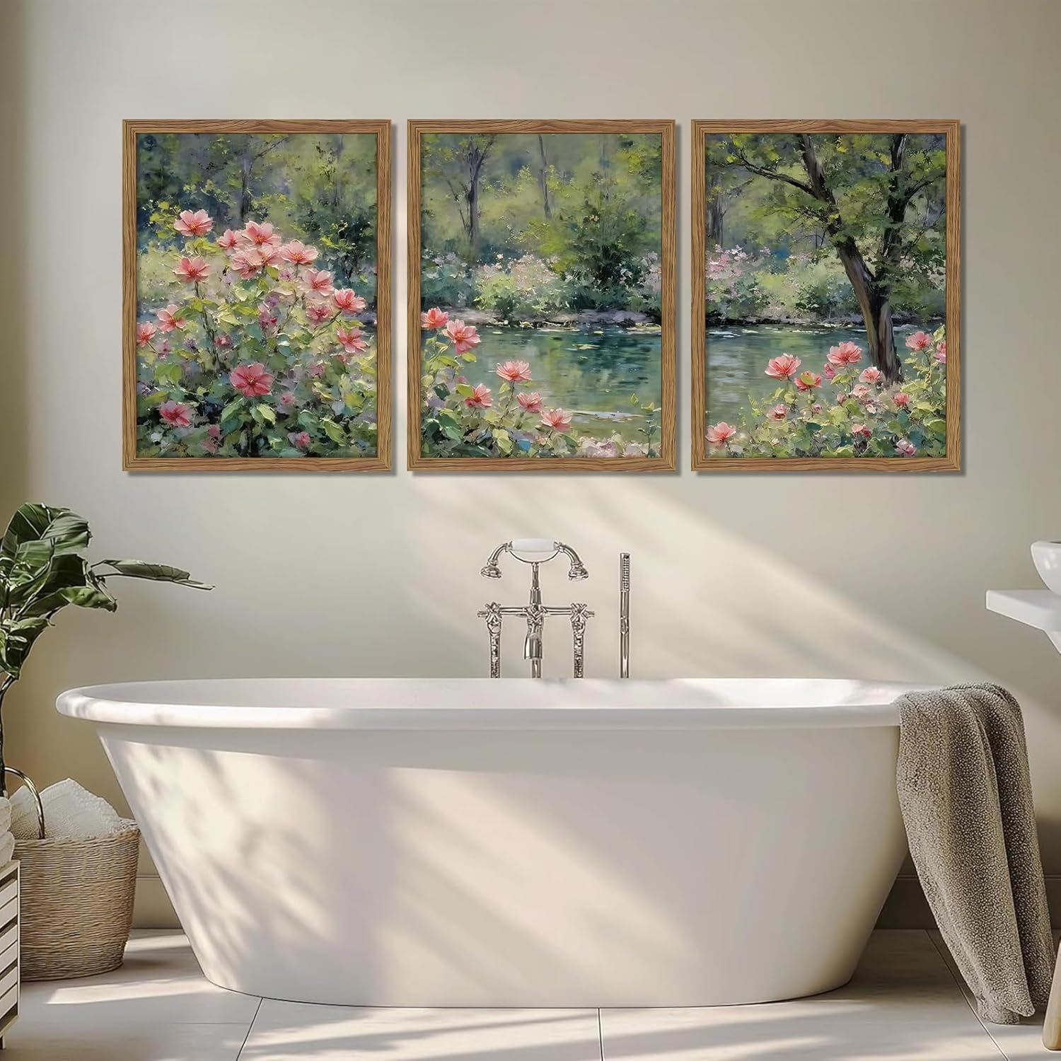 Three framed floral panels mounted above a freestanding white bathtub with soft sunlight and a towel draped on the tub.