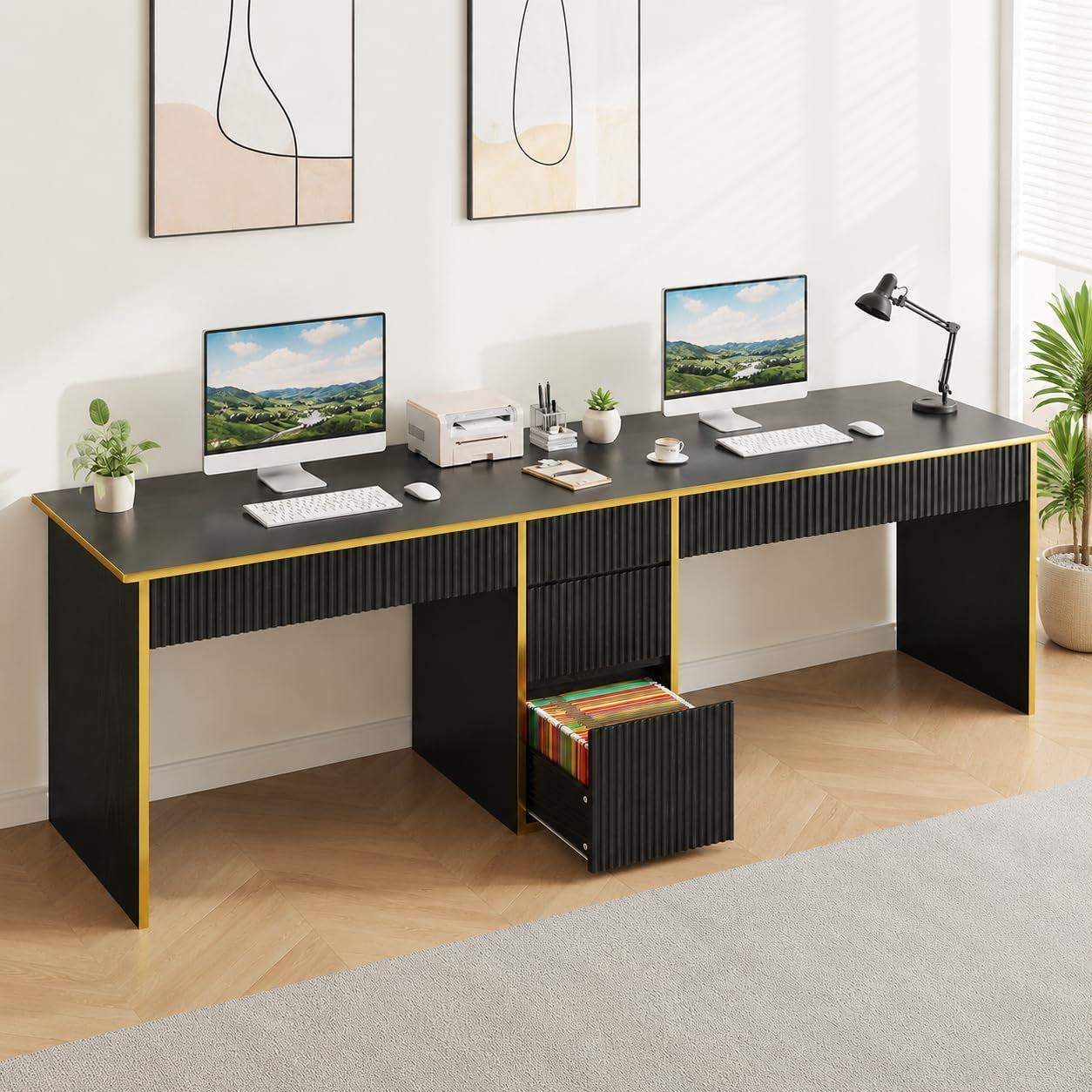 Long black desk with gold trim set up for two people; two monitors on top and a bottom file drawer open with folders.