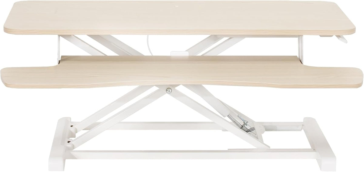 Front view of a pale natural wood standing desk converter with white metal X-frame base.