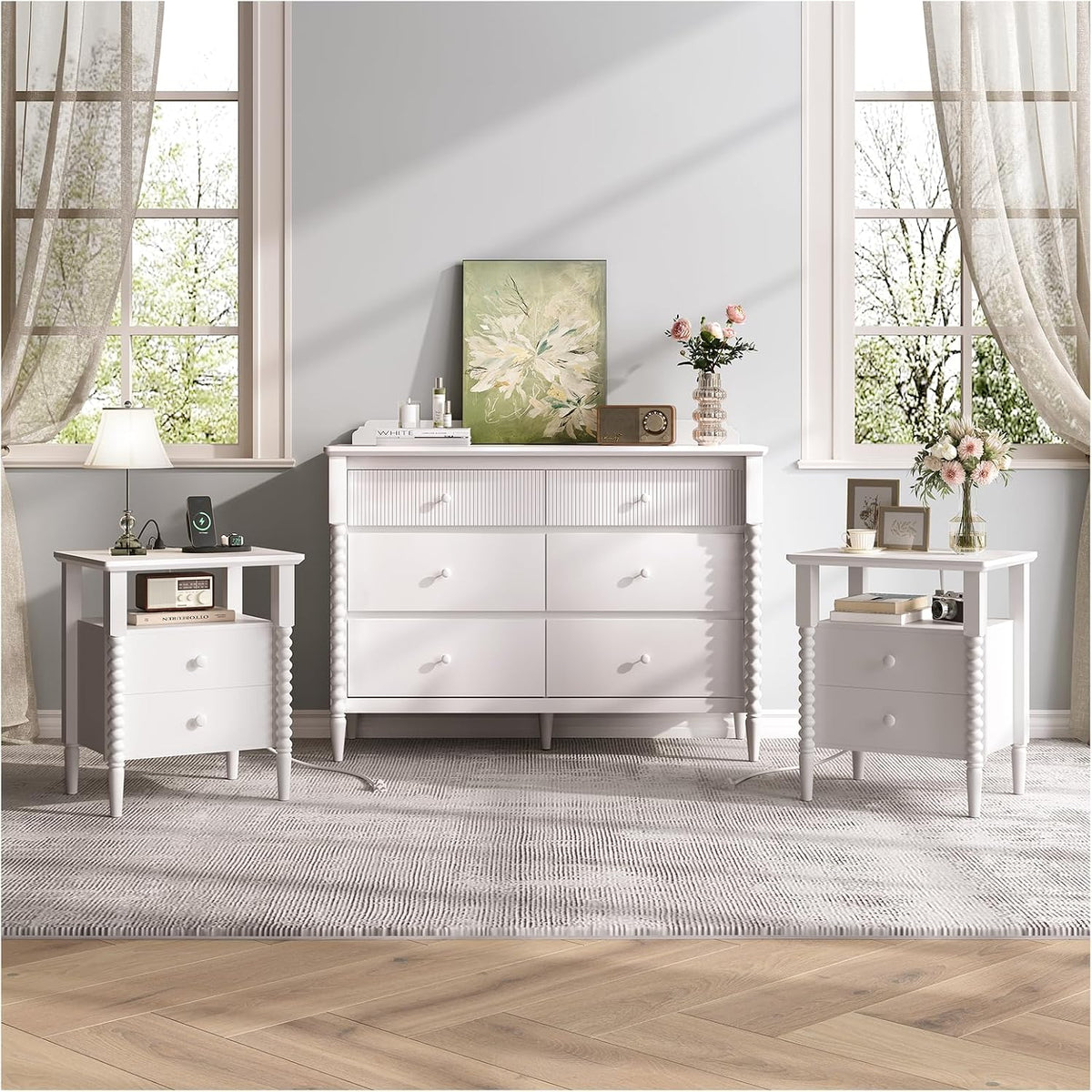 Full room scene showing a white dresser flanked by two matching white fluted nightstands under windows.
