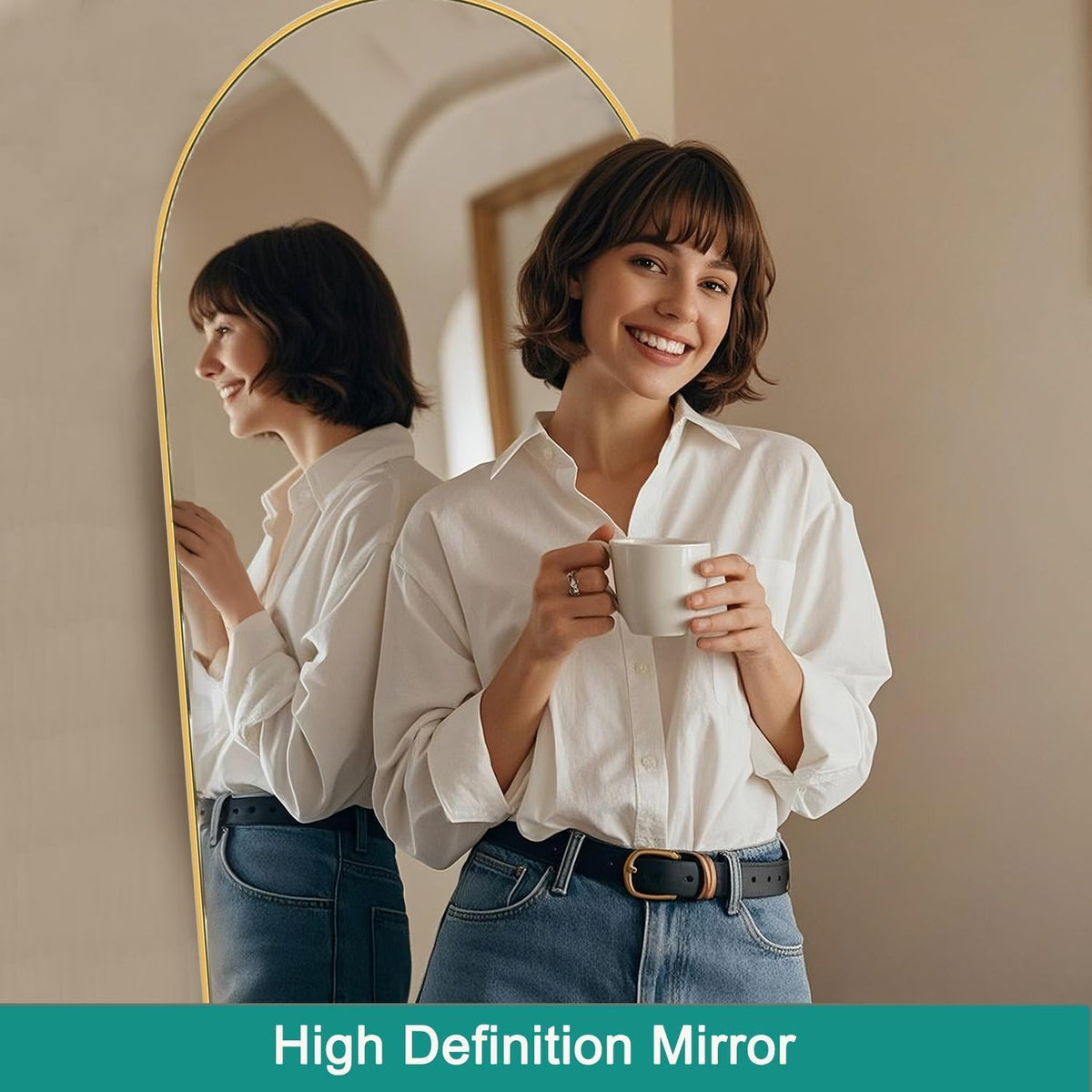 Arched full-length mirror with gold frame showing a smiling woman holding a mug and her reflection.