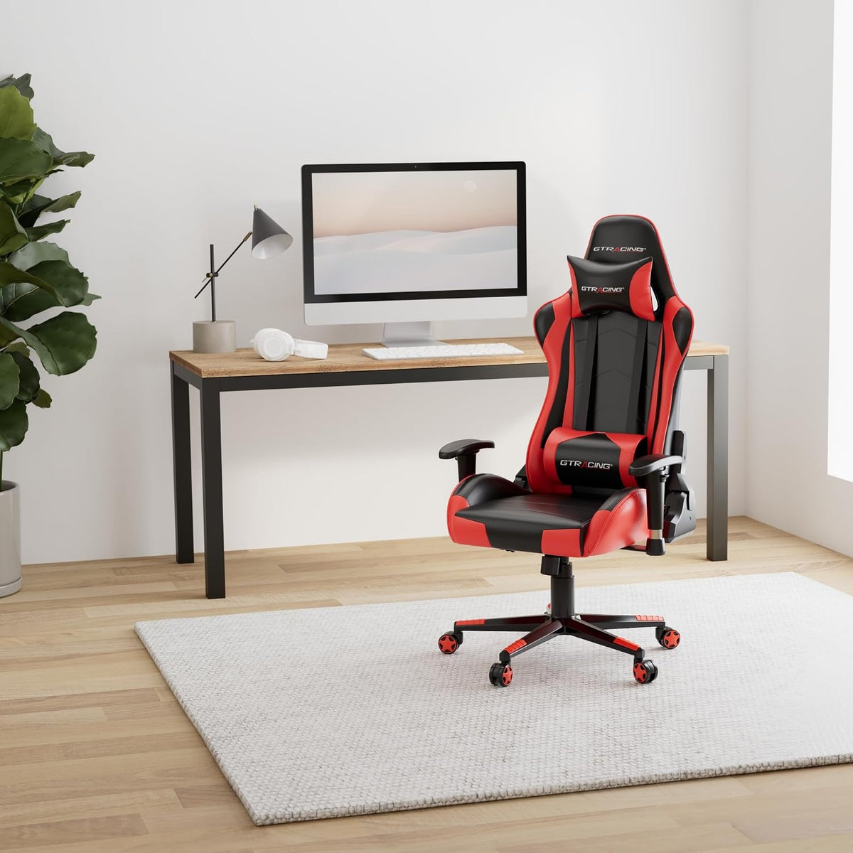 Red and black gaming chair placed in a minimalist home office next to a computer desk