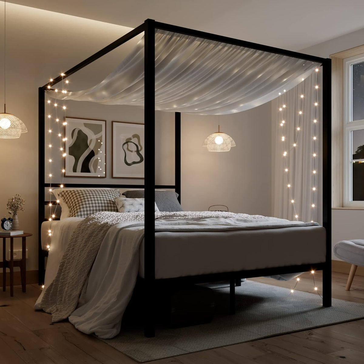 Black canopy bed frame styled with draped fabric and hanging string lights in a dimly lit bedroom