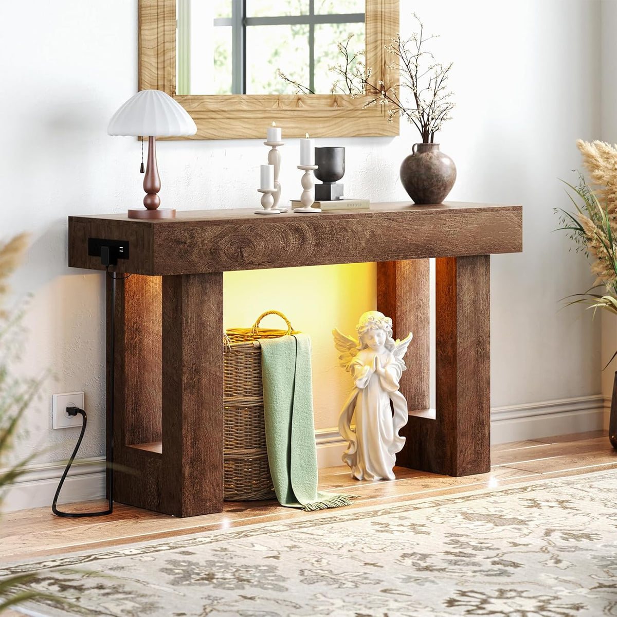 Dark brown console table front view with warm sensor light on, woven basket and a small angel statue tucked inside