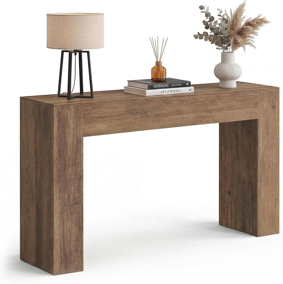 Angled front shot of the honey-brown U-shaped console styled with a lamp, books, and a vase.
