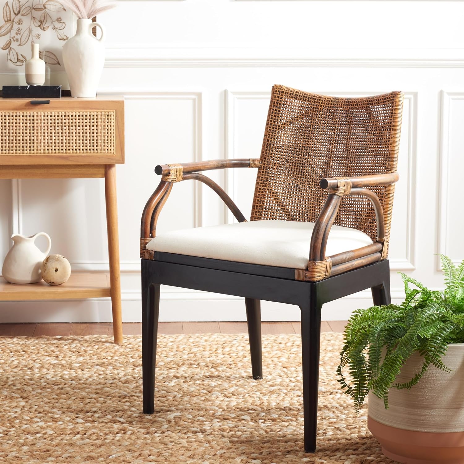 Rattan arm chair styled in a bright living room beside a console table on a woven rug