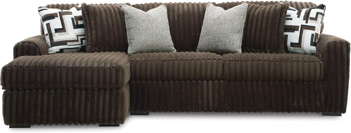 Front view of a chocolate-brown oversized sofa with a left chaise and mixed-pattern throw pillows.