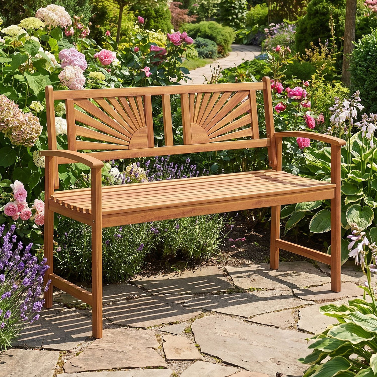 Wooden sunburst-back bench set on a garden path among colorful flowering plants.