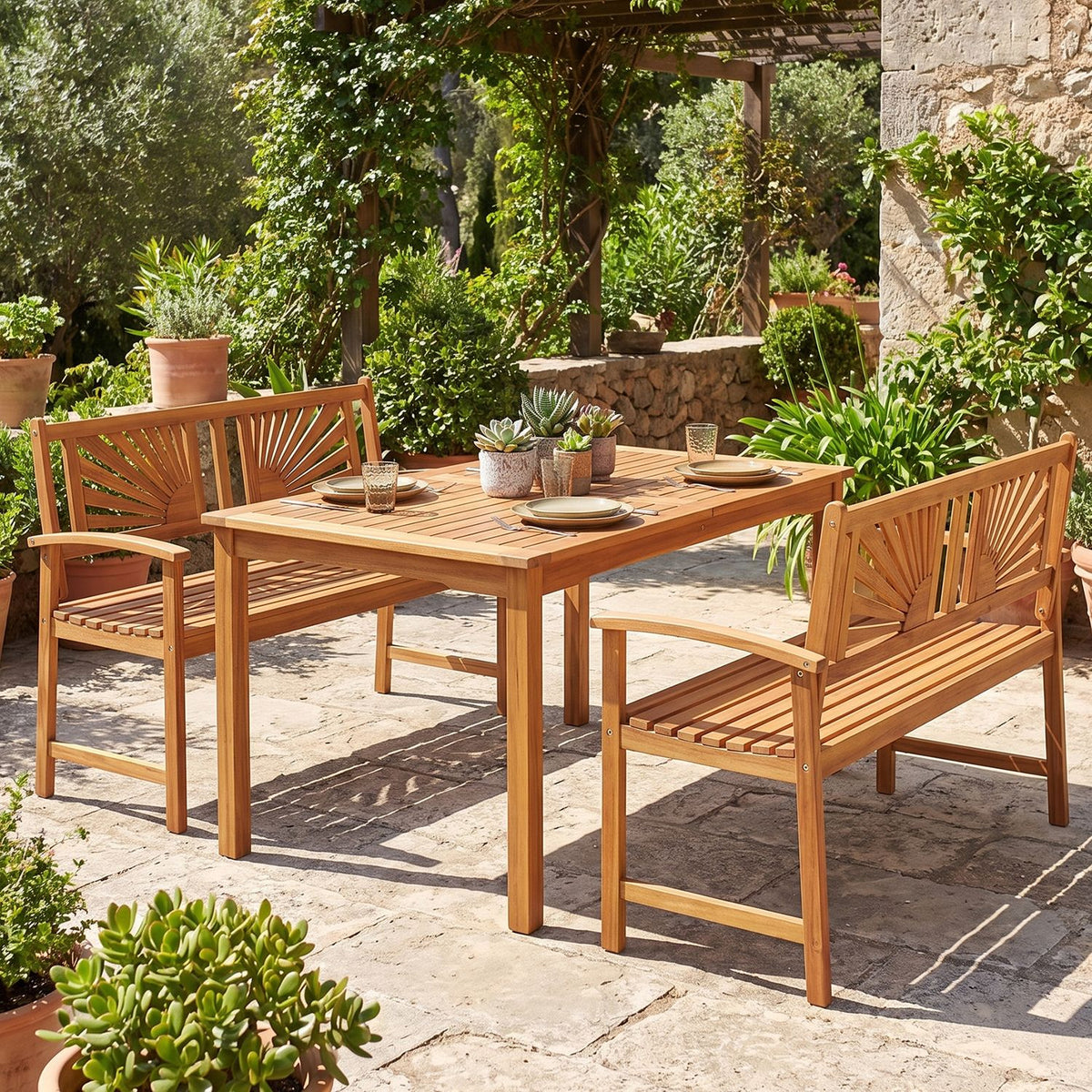 Wooden garden bench with a sunburst back sits beside a matching table and benches on a stone patio.