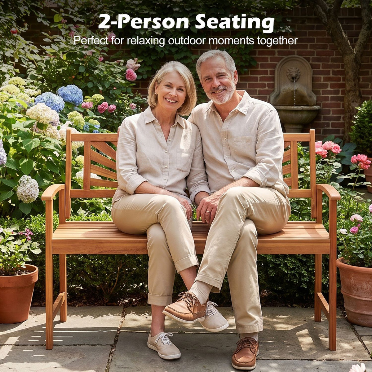 A smiling couple sits side by side on the wooden garden bench among flowering plants.