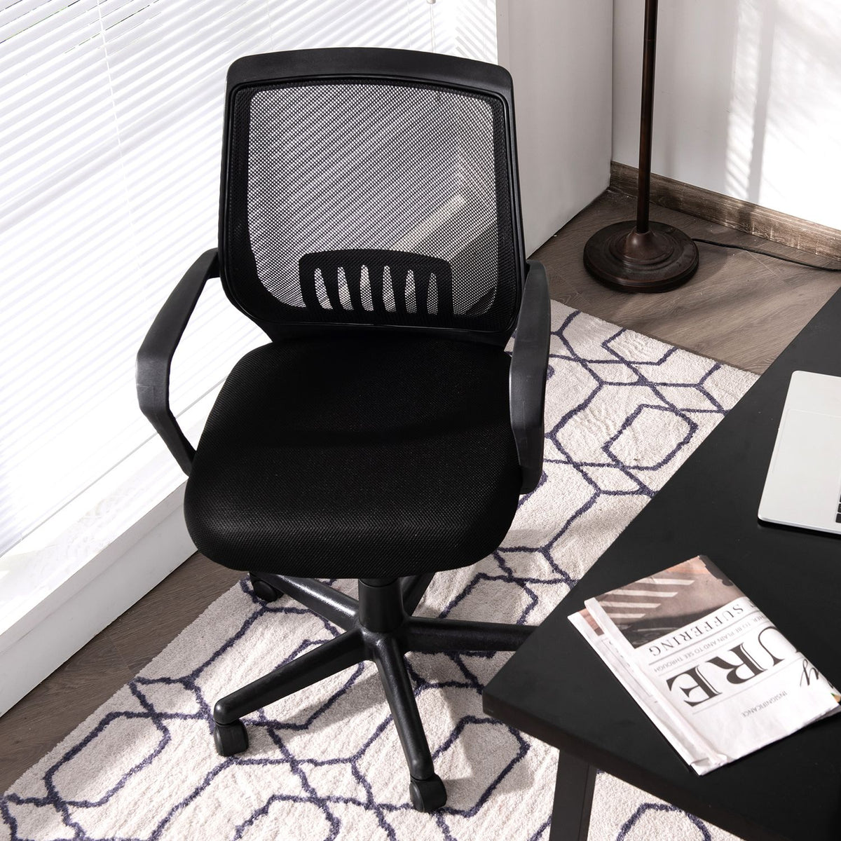 Black mesh office chair viewed from slightly above, with its seat and five-wheel base visible.
