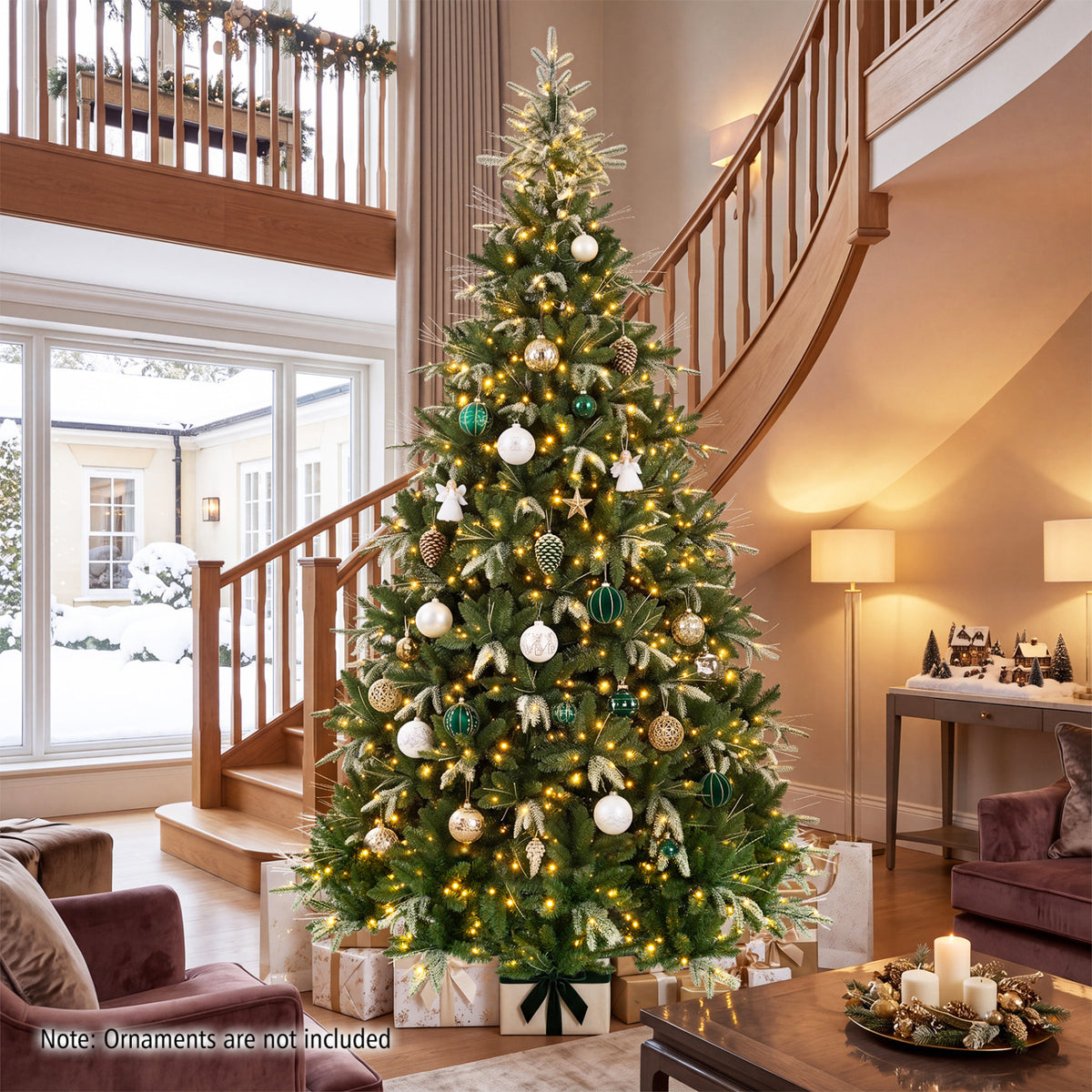 Decorated green Christmas tree with warm lights in a tall living room beside a staircase