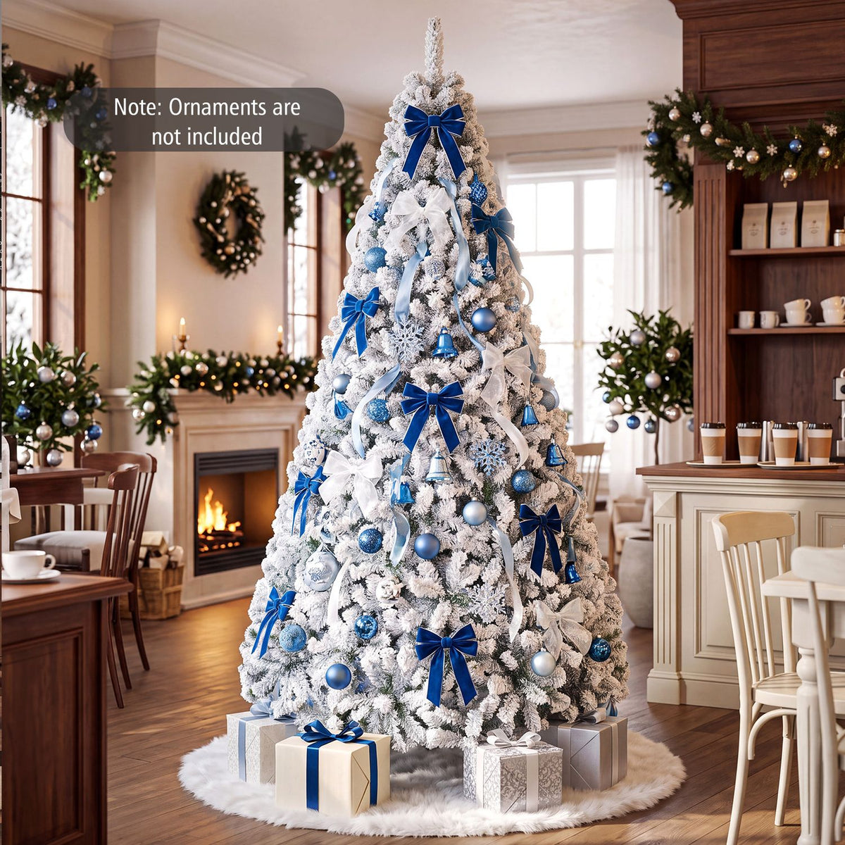 Snow-flocked tree decorated with blue bows and ornaments stands among dining tables and festive greenery.