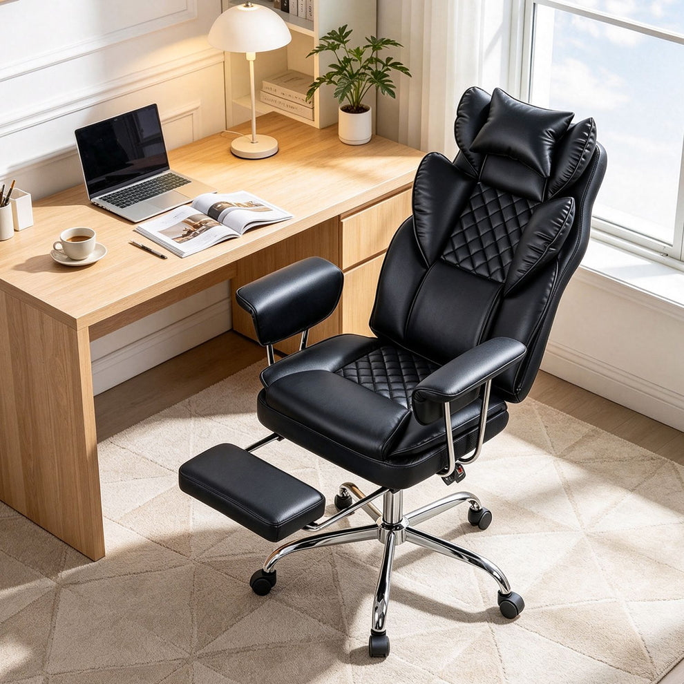 Black faux leather executive chair with footrest beside a desk in a bright home office