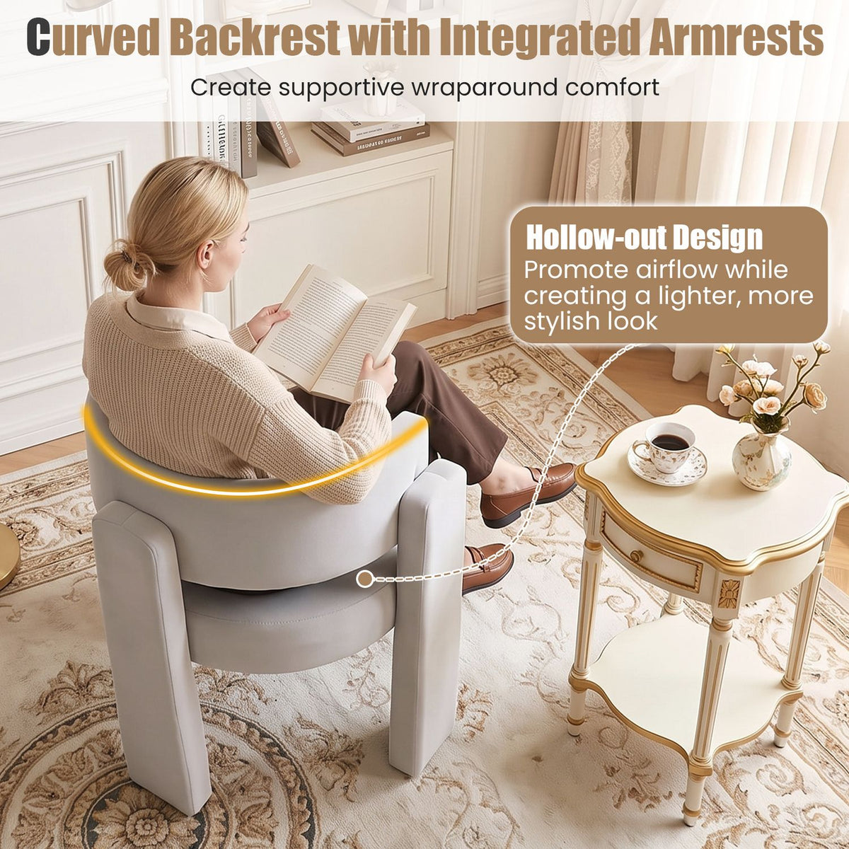 A woman reading in a light gray barrel chair with an open back beside a small table.