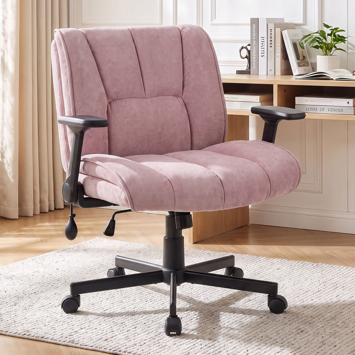 Pink upholstered office chair with padded arms and a black wheeled base in a home office.